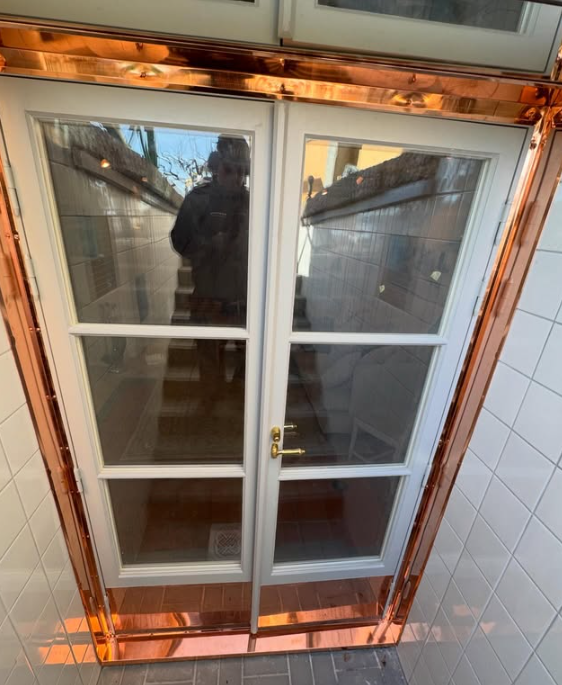 Kopparinklädda dörrkarmar vid entré, plåtslageri i detalj